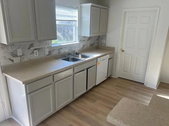 a kitchen with a sink cabinets and window