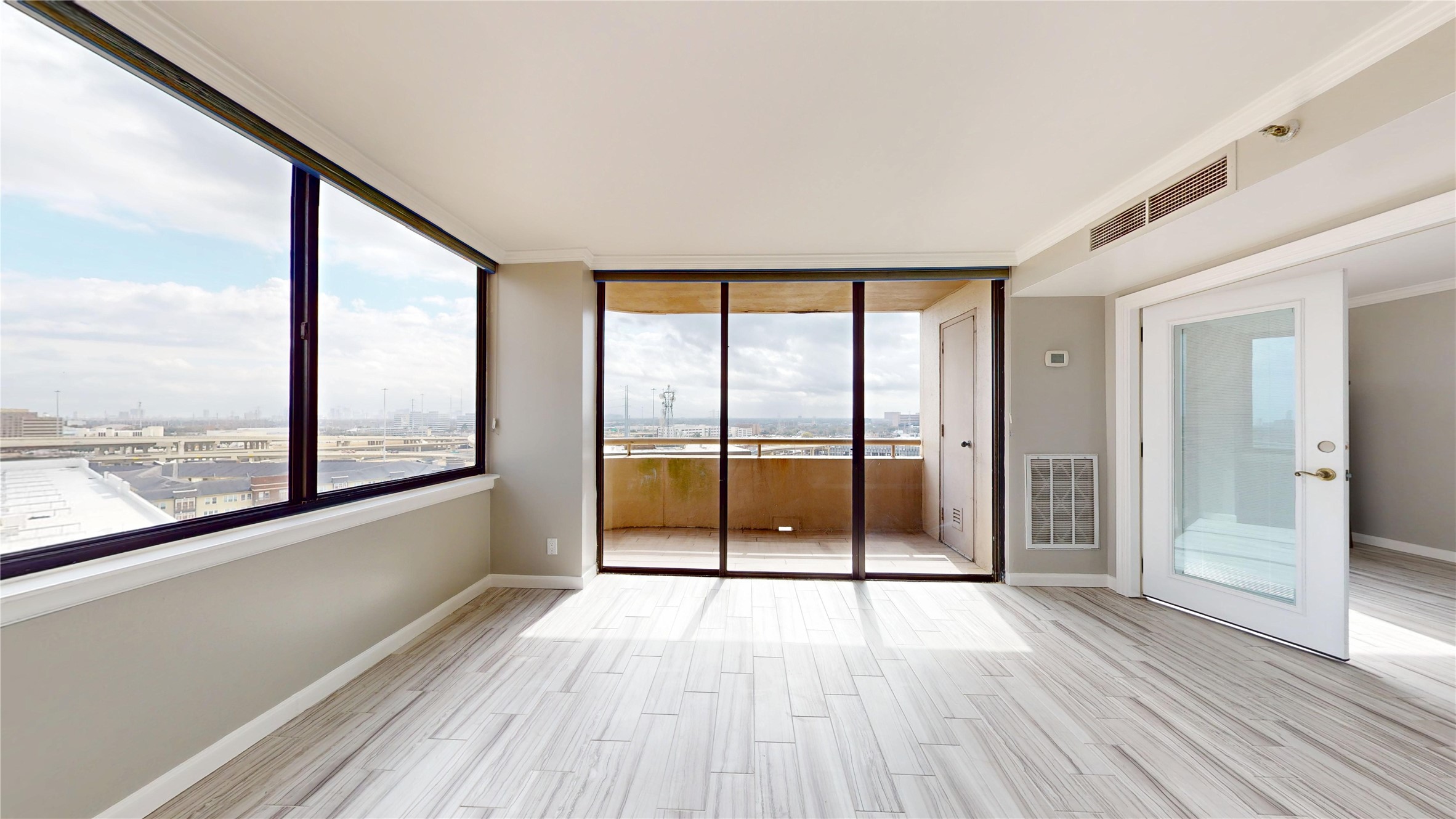 3525 Sage Road, Unit 1404 Houston, TX 77056 - Photo 5 of 36 a view of an empty room with wooden floor and windows