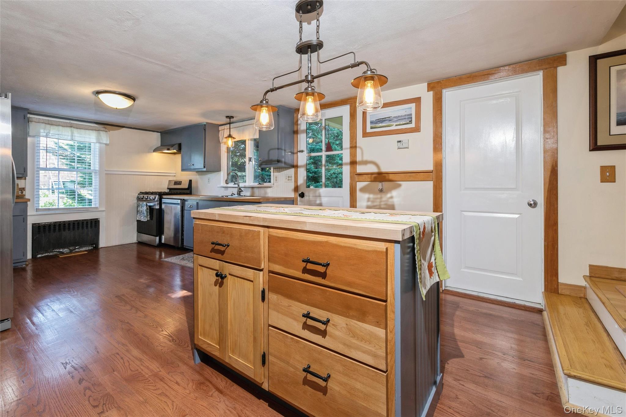 240 Wicks Road New Suffolk, NY 11956 - Photo 11 of 36 a kitchen with a stove a refrigerator a sink and wooden floor