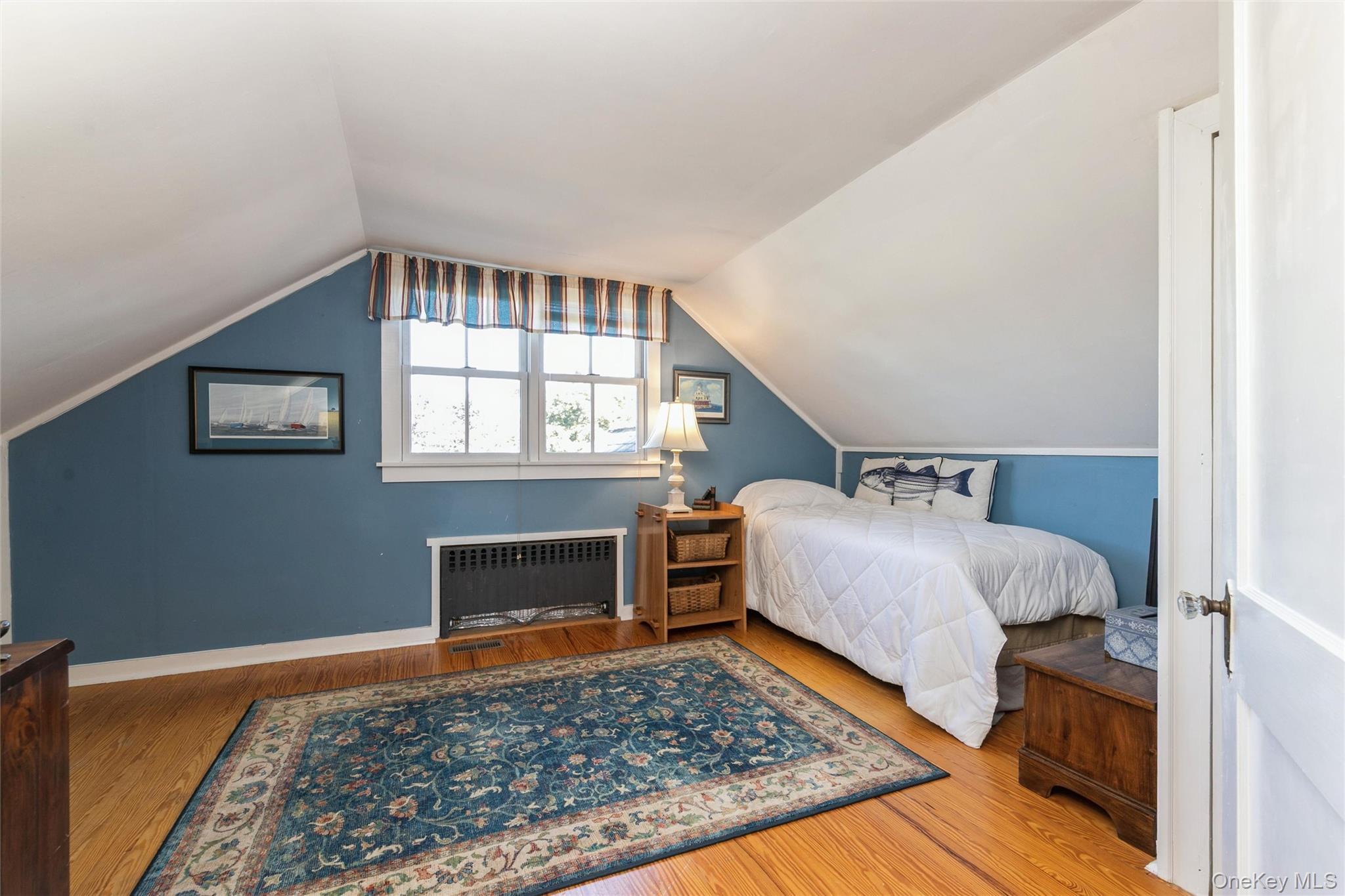 240 Wicks Road New Suffolk, NY 11956 - Photo 21 of 36 a bedroom with a bed and wooden floor