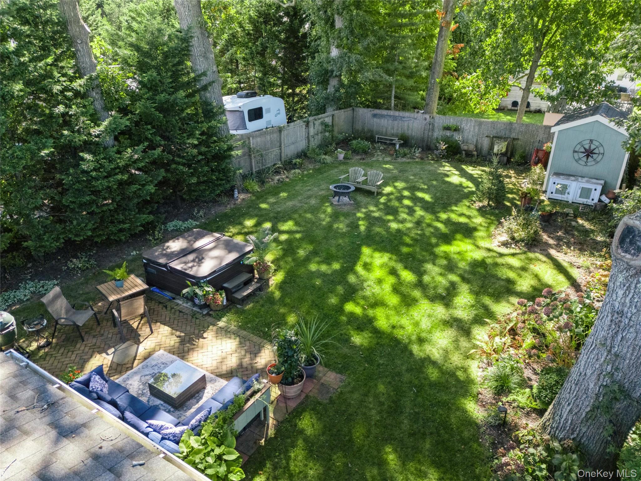 240 Wicks Road New Suffolk, NY 11956 - Photo 25 of 36 a backyard of a house with chairs and a fire pit