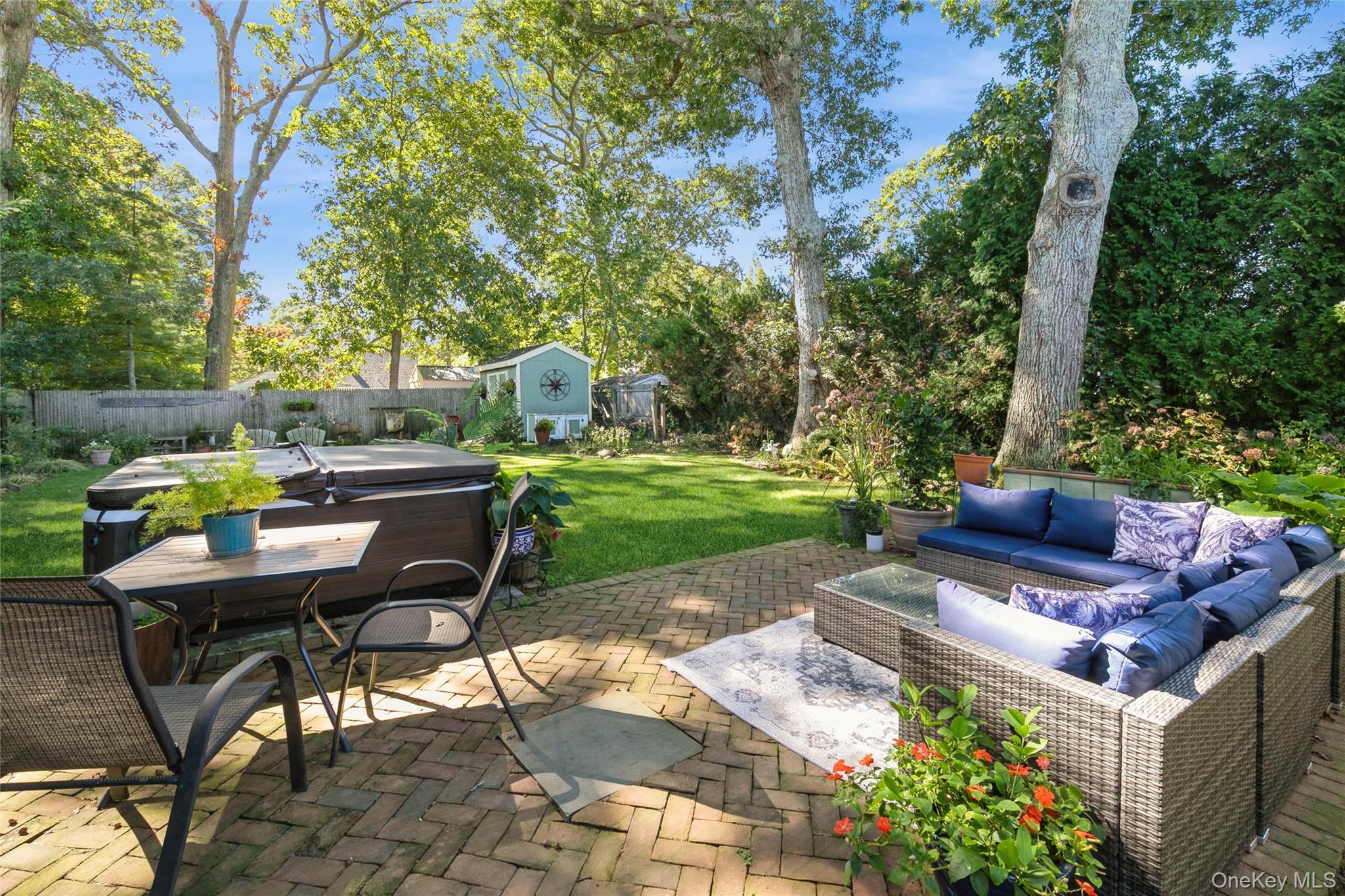 240 Wicks Road New Suffolk, NY 11956 - Photo 27 of 36 a view of a patio with table and chairs potted plants and large tree