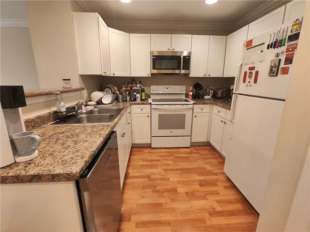 a kitchen with a sink and wooden floor