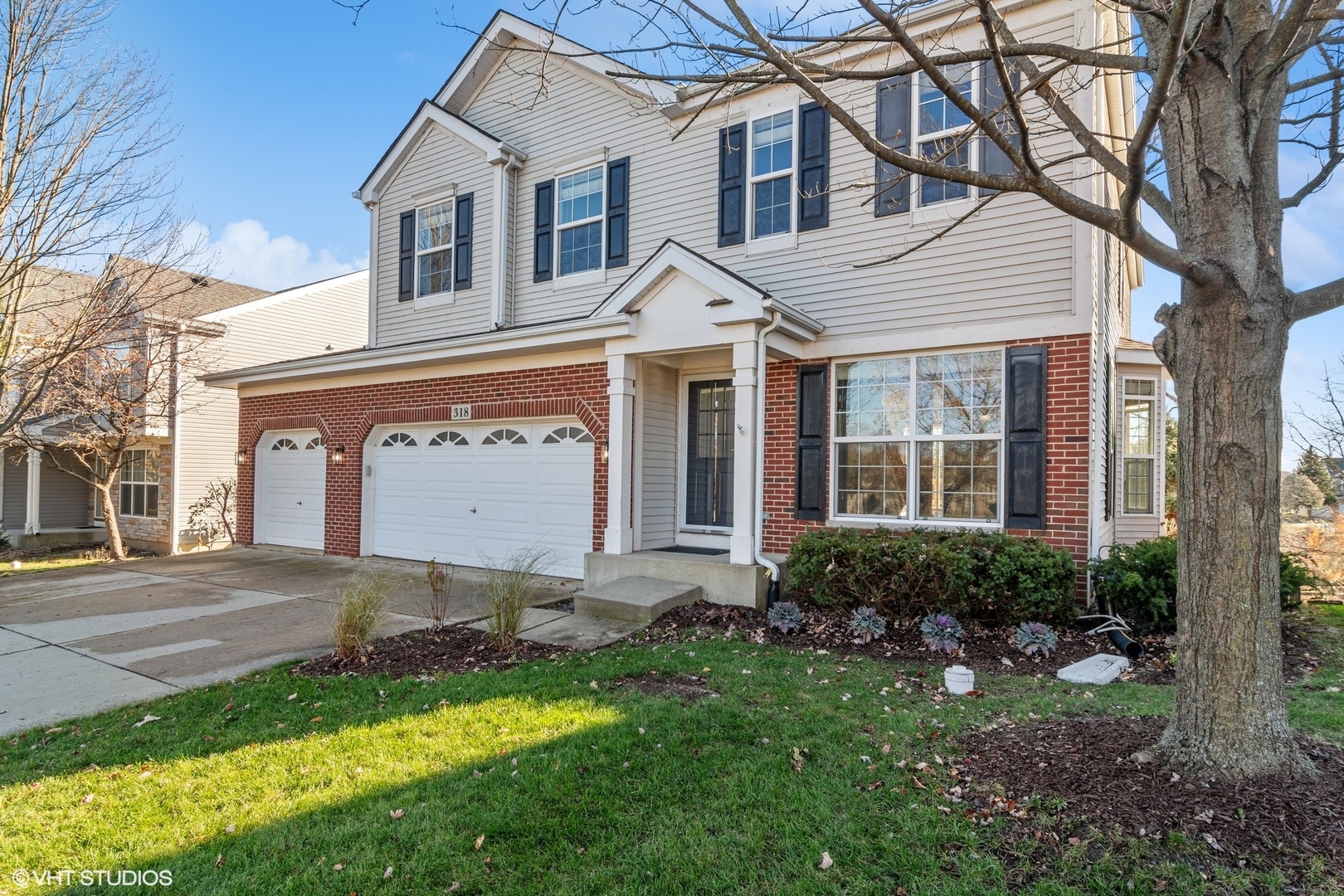 a white house with a small yard and large trees