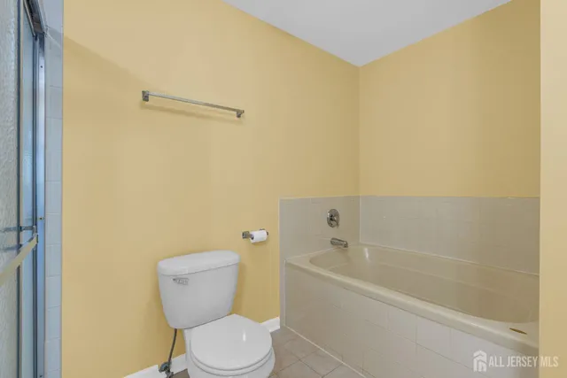 a white toilet sitting next to a bath tub