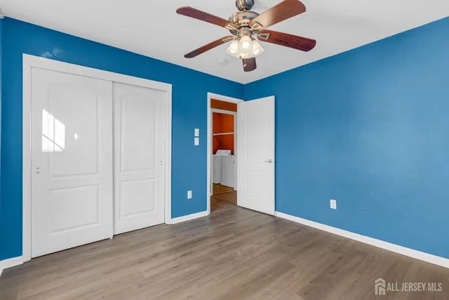 an empty room with closet and fan