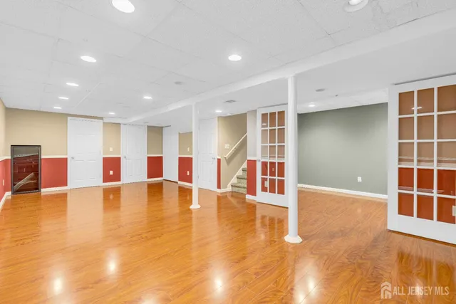 a view of empty room with wooden floor and floor to ceiling window