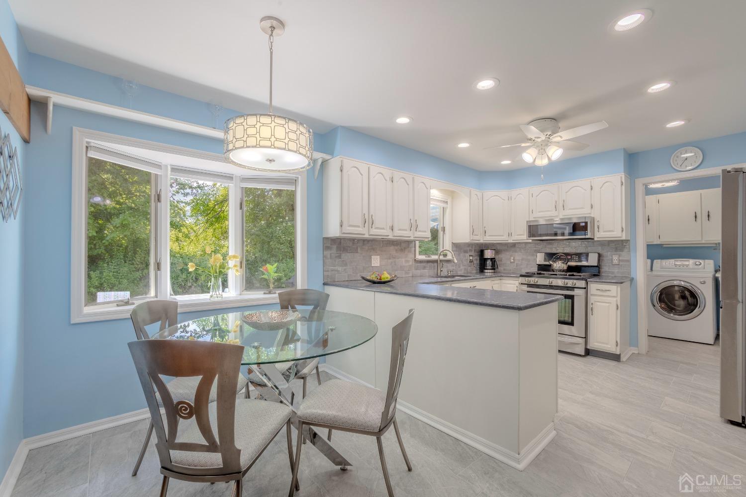 4 Putnam Road East Brunswick, NJ 08816 - Photo 13 of 53 a kitchen with a dining table chairs stainless steel appliances and cabinets