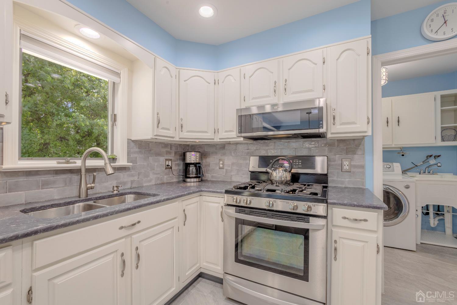 4 Putnam Road East Brunswick, NJ 08816 - Photo 18 of 53 a kitchen with granite countertop white cabinets white appliances a sink and a window