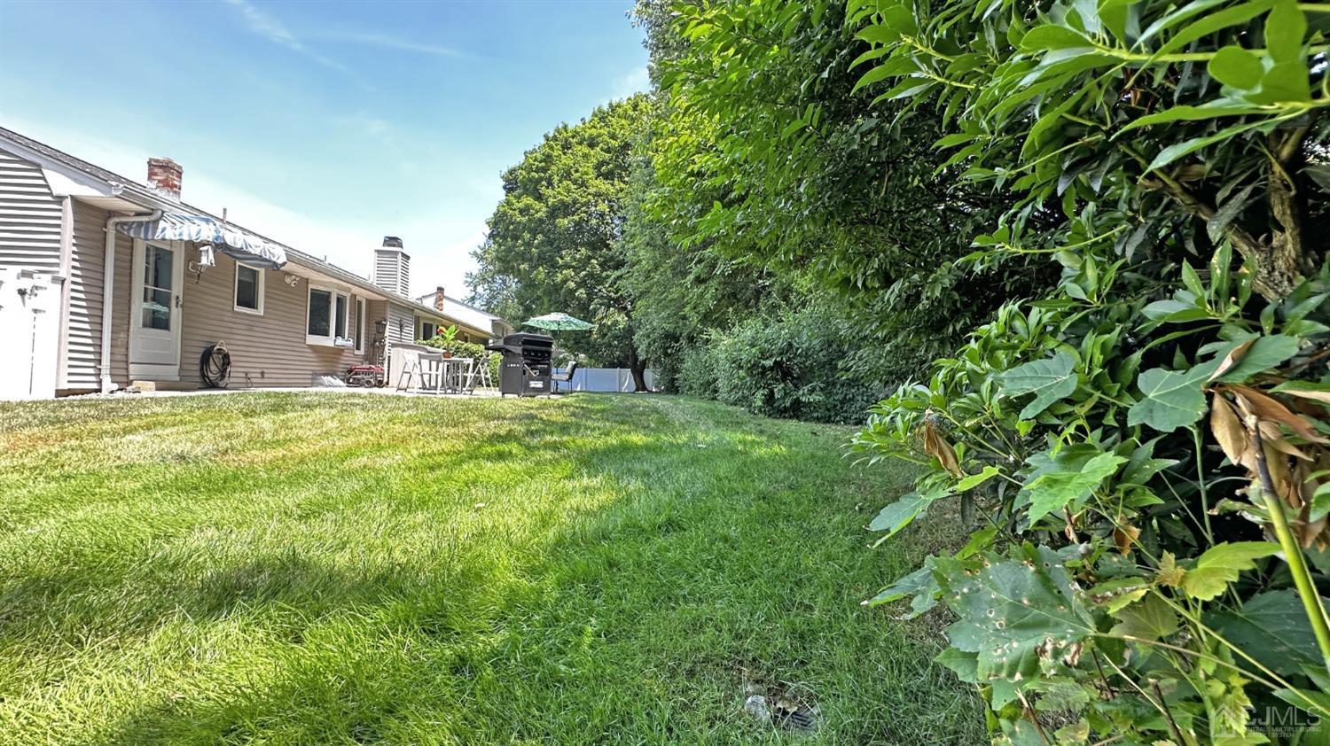 4 Putnam Road East Brunswick, NJ 08816 - Photo 47 of 53 a backyard of a house with large trees and plants