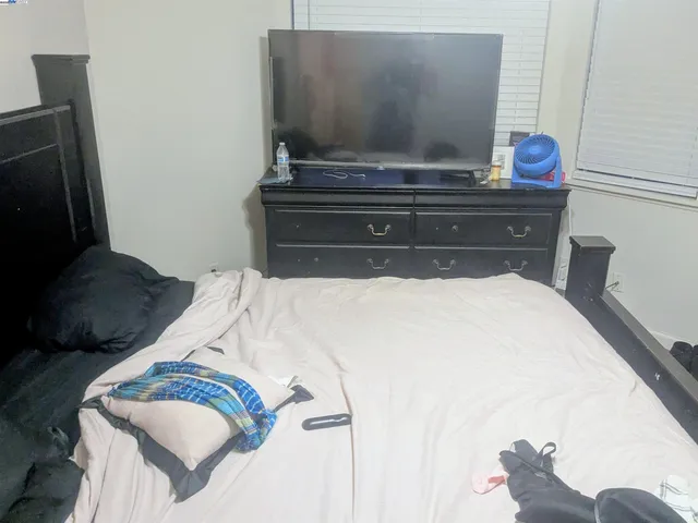a view of bedroom with a bed and wooden floor