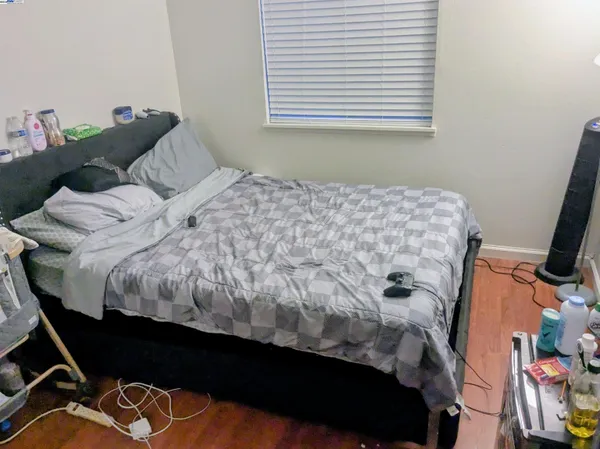 a bed sitting in a bedroom next to a window