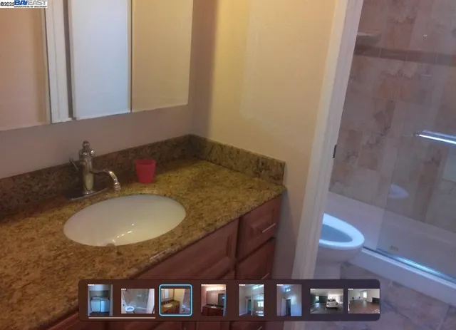 a bathroom with a granite countertop sink and a mirror