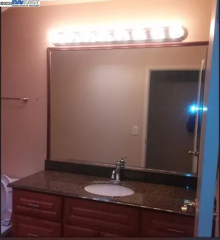 a bathroom with a granite countertop sink and mirror