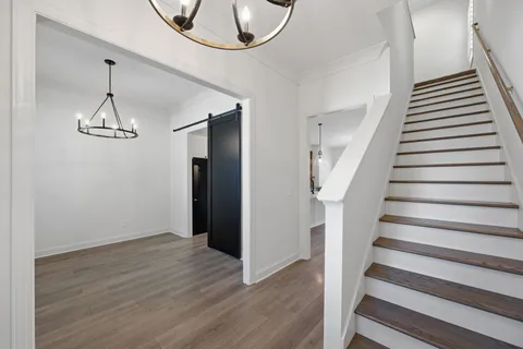 a view of an empty room with wooden floor and window