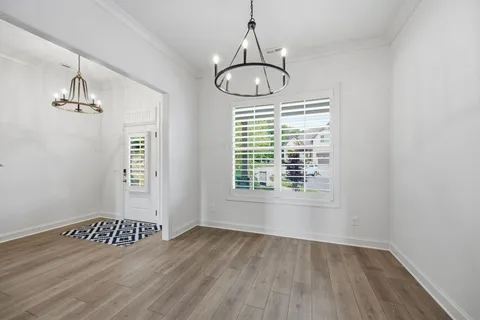 a kitchen with stainless steel appliances granite countertop a sink a stove a refrigerator and a wooden floor
