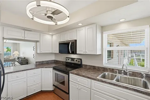 a kitchen with a sink dishwasher a stove and a microwave oven