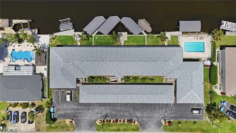 an aerial view of a swimming pool with outdoor seating