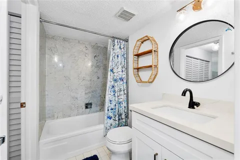 a bathroom with a sink a mirror a toilet and a shower