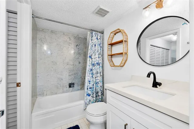 a bathroom with a sink a mirror a toilet and a shower