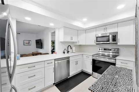a kitchen with stainless steel appliances kitchen island granite countertop a sink and cabinets