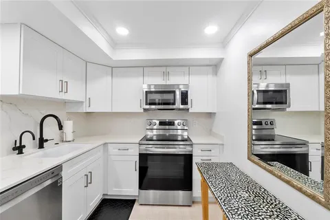 a kitchen with stainless steel appliances a stove sink and cabinets