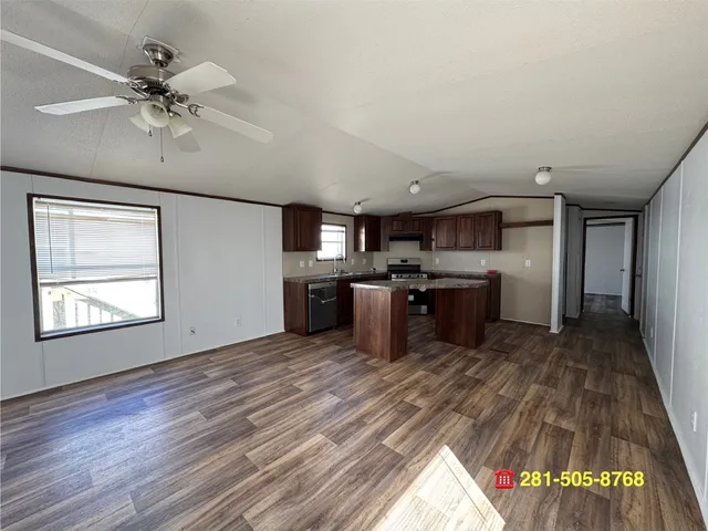 a large kitchen with a lot of cabinets appliances and a wooden floor