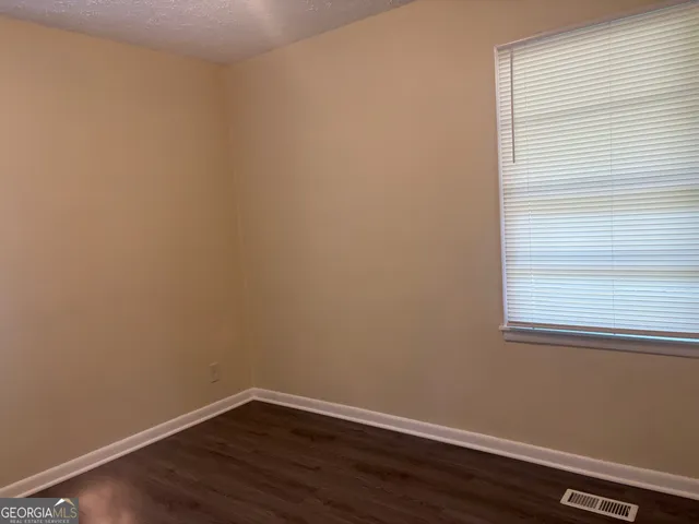 a view of a small space with wooden floor and a window