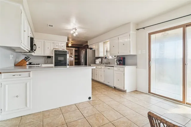 a kitchen with stainless steel appliances a refrigerator sink and cabinets
