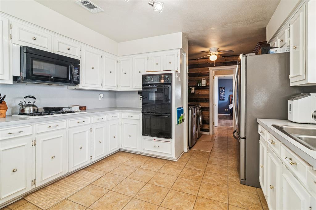 903 Houston Street Anna, TX 75409 - Photo 12 of 27 a kitchen with stainless steel appliances a refrigerator sink and microwave