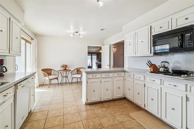 a kitchen with cabinets and chairs
