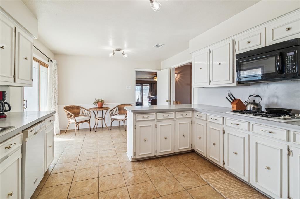 903 Houston Street Anna, TX 75409 - Photo 14 of 27 a kitchen with cabinets and chairs