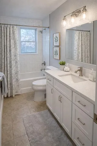 a spacious bathroom with a double vanity sink toilet and a bathtub