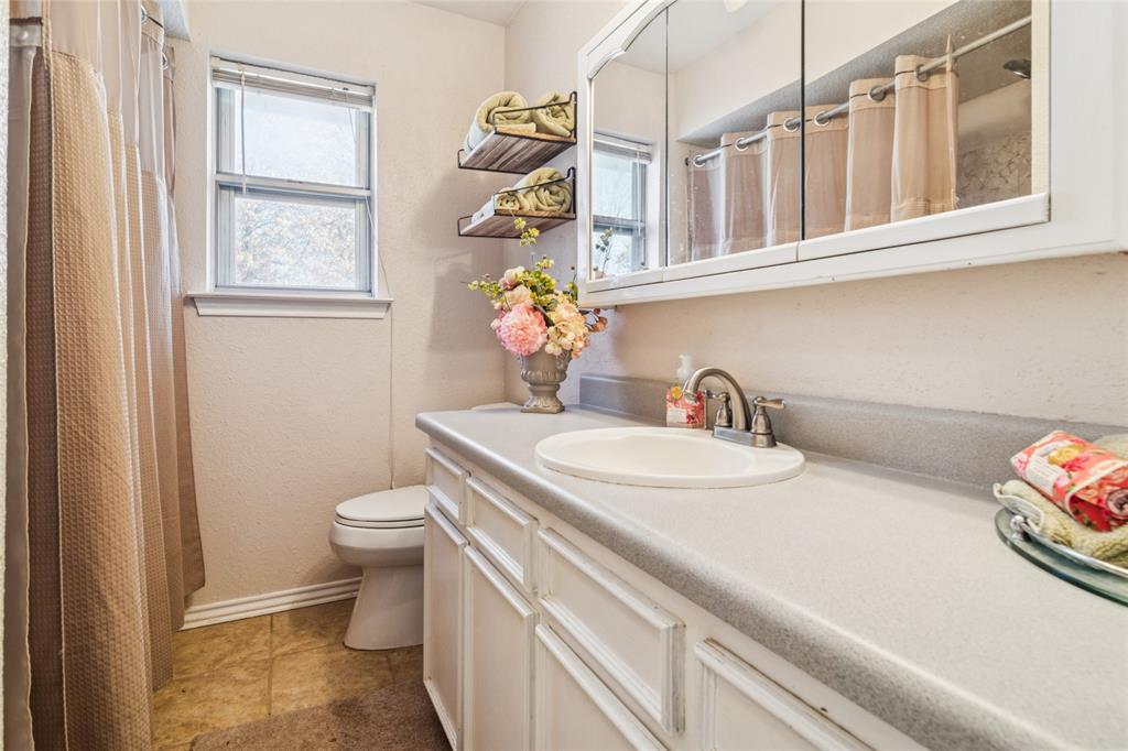 903 Houston Street Anna, TX 75409 - Photo 22 of 27 a bathroom with a sink a toilet and a window