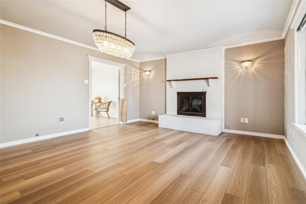 903 Houston Street Anna, TX 75409 - Photo 4 of 27 a view of an empty room with wooden floor fireplace and a window