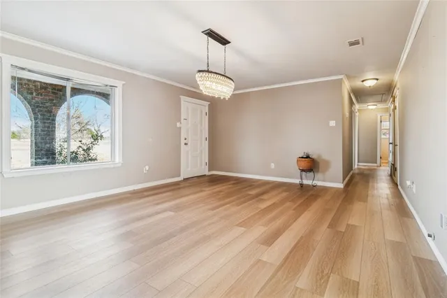 a view of a livingroom with wooden floor and a chandelier