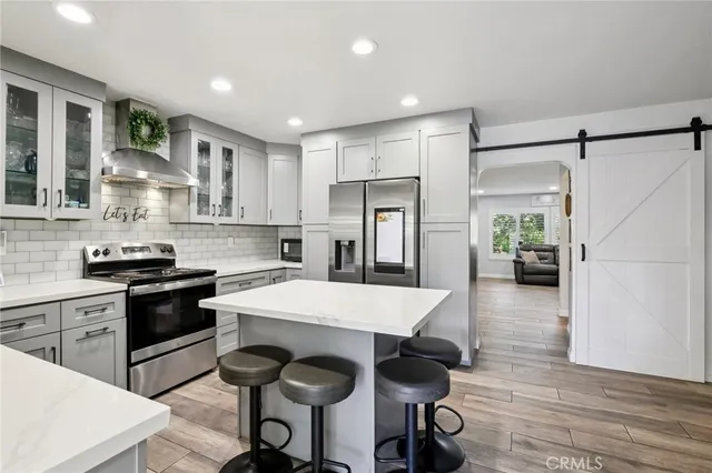 a kitchen with granite countertop white cabinets and stainless steel appliances