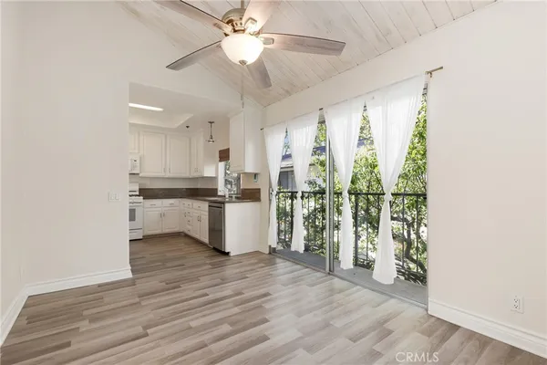 a view of a kitchen with wooden floor and a ceiling fan