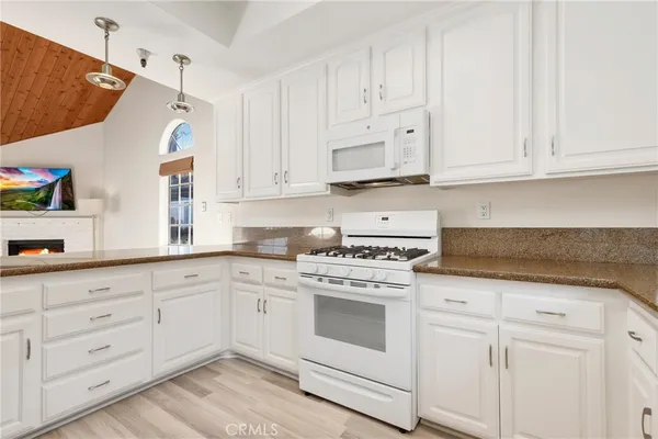 a kitchen with white cabinets and white appliances