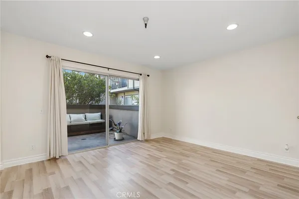 a big room with wooden floor and a window