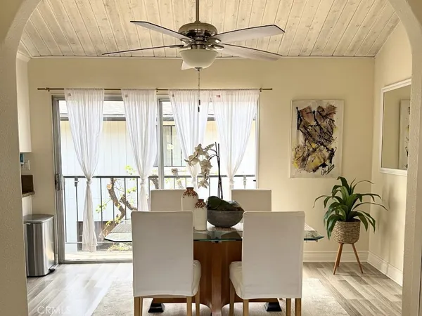 a dining room with furniture potted plants and wooden floor