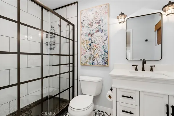a bathroom with a sink toilet vanity and shower