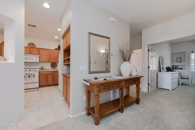 a room with kitchen island stainless steel appliances a sink cabinets and a counter top space