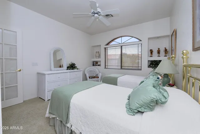 a bedroom with two beds and a large window