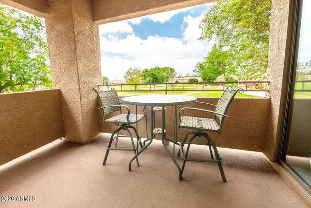 a view of an outdoor sitting area with furniture and a yard