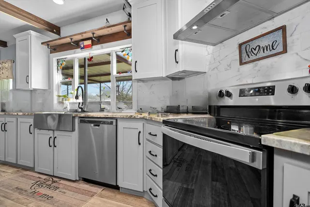 a kitchen with stainless steel appliances granite countertop a sink and cabinets