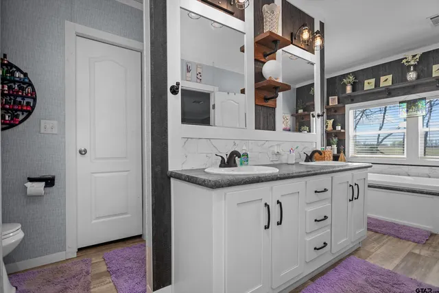 a spacious bathroom with a granite countertop bathtub and window