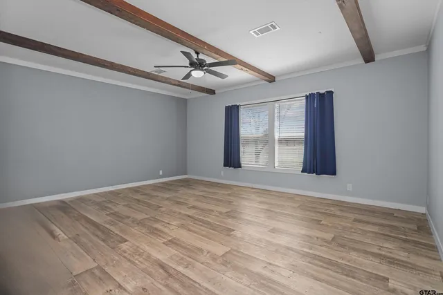 a view of an empty room with wooden floor