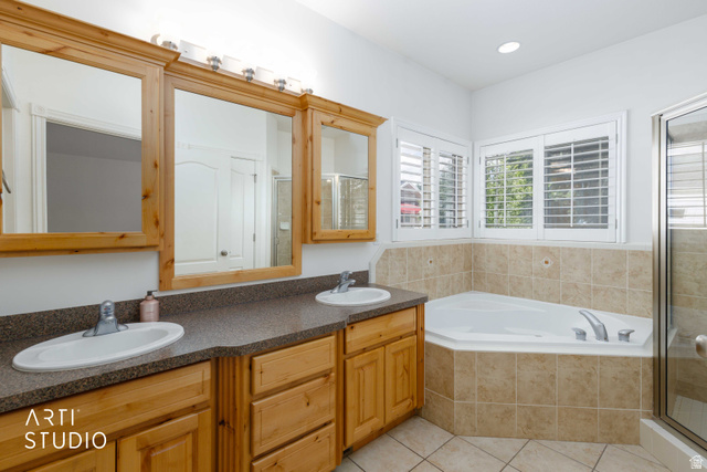 2327 Bluff Ridge Drive Syracuse, UT 84075 - Photo 23 of 66 Bathroom featuring a corner soaking tub with tile surround, a double vanity with wood cabinetry, and plantation shutters