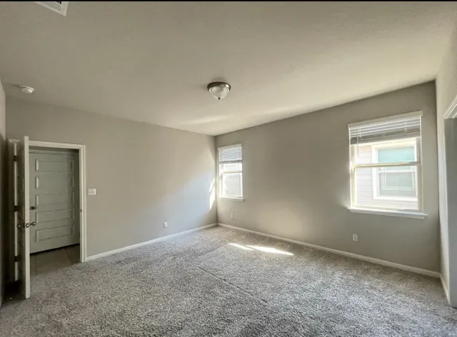 an empty room with windows and closet